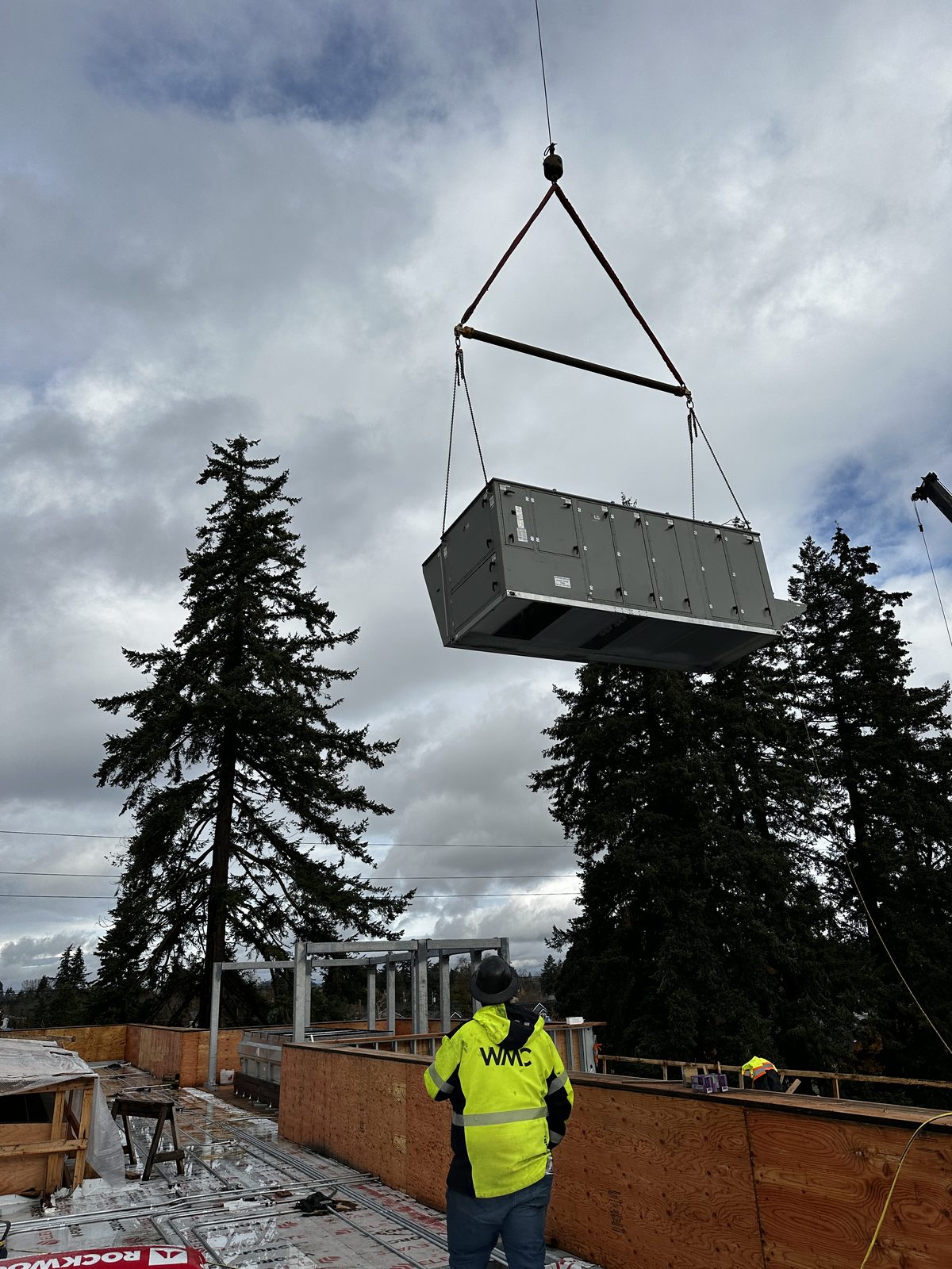 Crane setting a rooftop unit